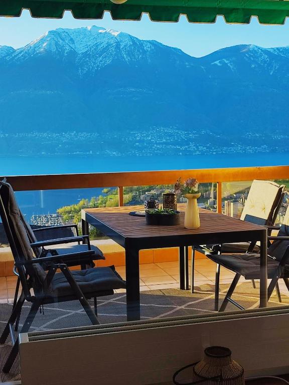 a table and chairs on a balcony with a view of a mountain at Ferienwohnung C06 in Orselina