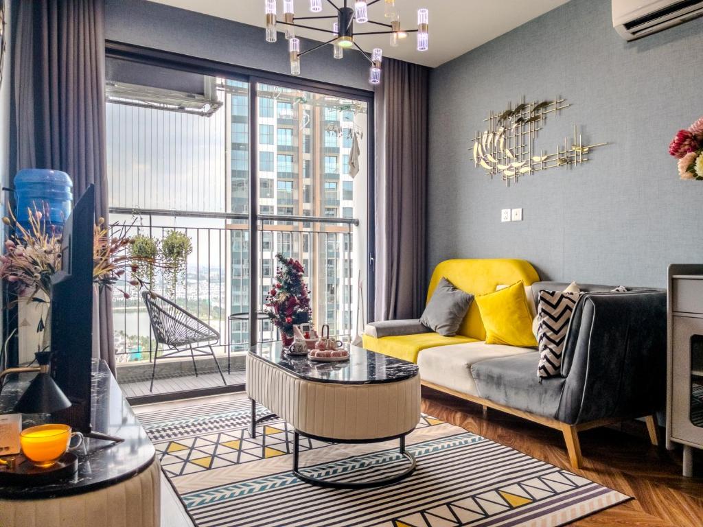a living room with a couch and a large window at Vinhomes Ocean Park Gia Lam by QMP in Hanoi