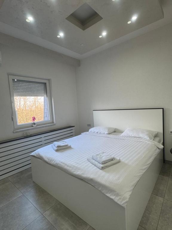 a white bedroom with a large bed with towels on it at Motel Marco Polo in Gredice