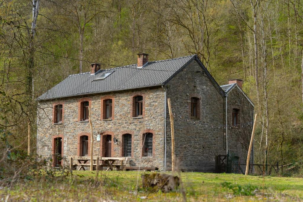 an old brick house in the middle of a field at Maison de la Turbine in Yvoir