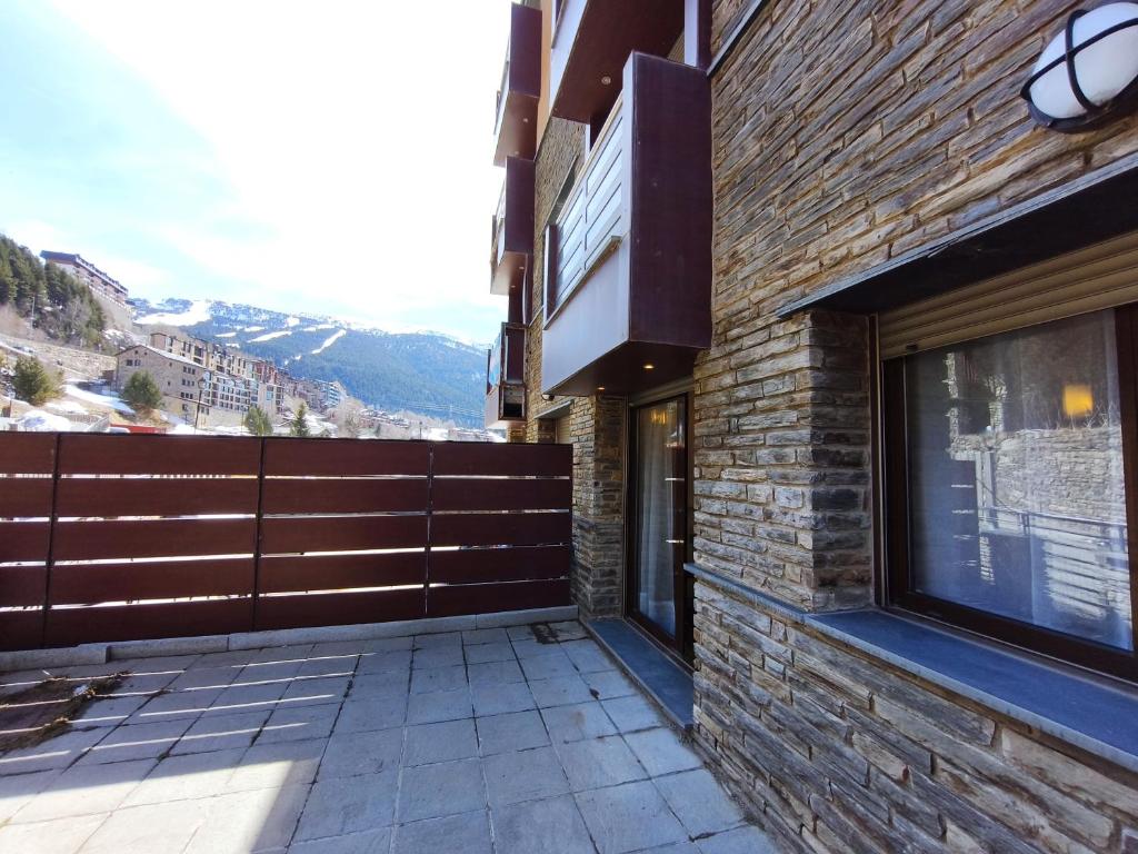 a brick building with a fence on the side of it at AC Apartaments Cabirol Incles in Incles