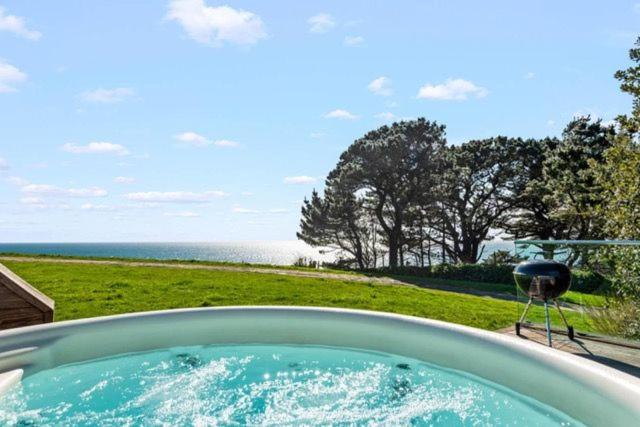 a bath tub with a view of the ocean at House 35 in Looe