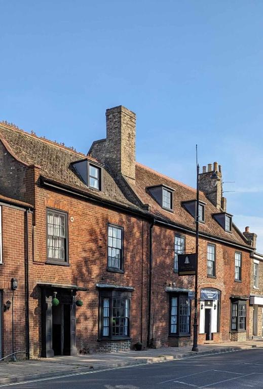an old brick building on the corner of a street at The Bell Hotel in Mildenhall