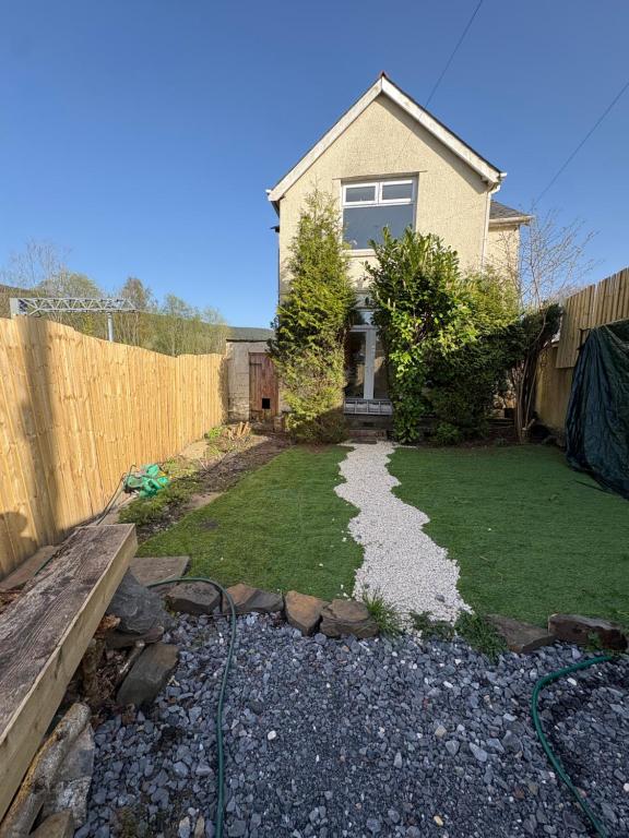 a yard with a fence and a house at Mountain Ash Cottage in Mountain Ash