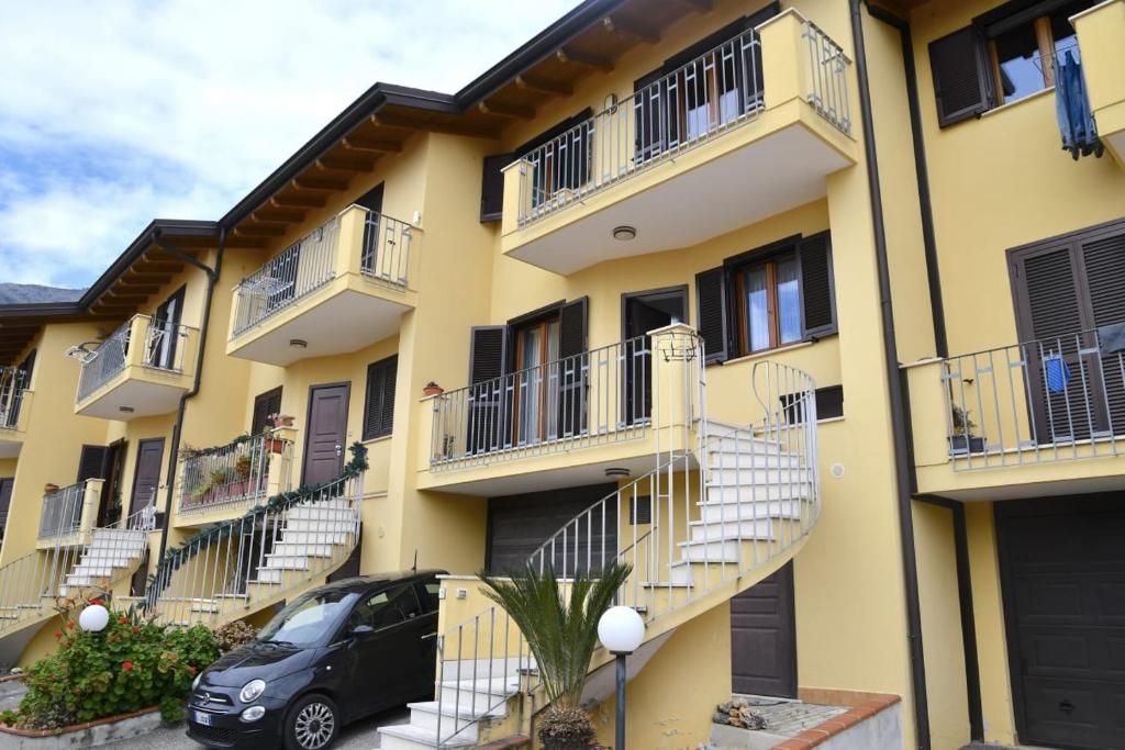 a building with balconies and a car parked in front at Villa Mare Monti in Maranola