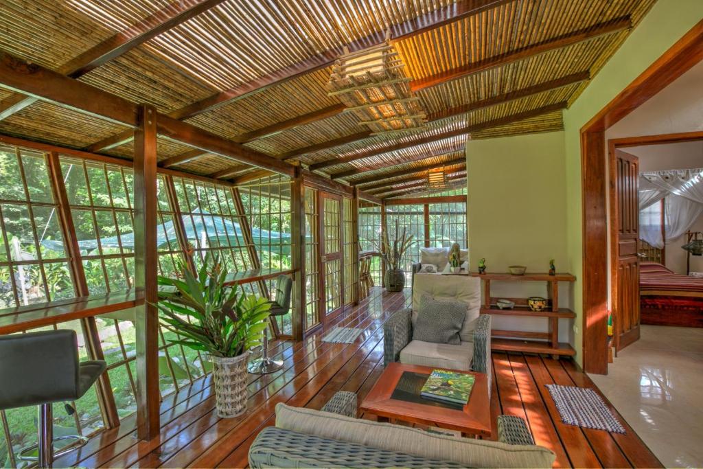 a living room with a wooden ceiling and windows at Uva Blue Villas - Zen Villa 1 - 3 Bedroom Villa, Private Garden & Yoga Deck in Puerto Viejo