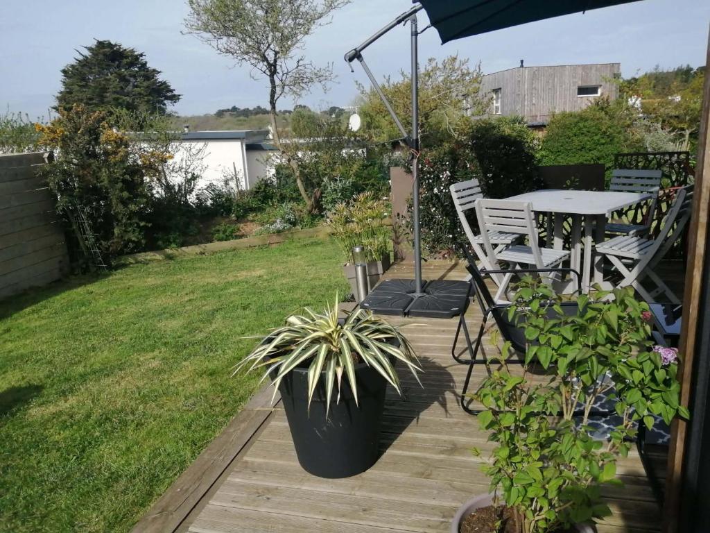 a patio with a table and chairs in a yard at Cottage chaleureux in Locquirec