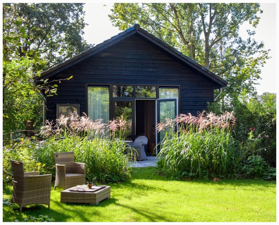 a small black house with a garden in the yard at De Witte Kip in Ruinen