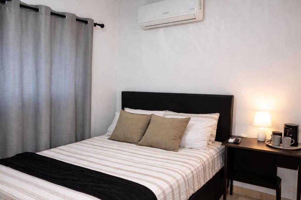 a bedroom with a bed with a black and white blanket at Sunlit Retreat Private Flatlet with Solar Power Pool Fast WiFi & Secure Parking in Roodepoort