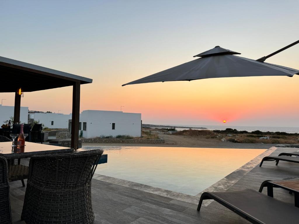 a patio with a table and an umbrella over a pool at Esentepe Collection Nothern Cyprus Villas & Apartments with Sea View Nothern Cyprus in Pallouriotissa