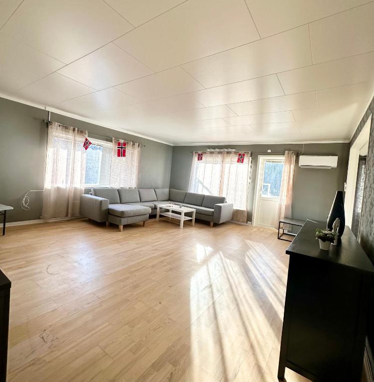 a living room with a couch and a table at Spacious seaside apartment with balcony in Sorreisa