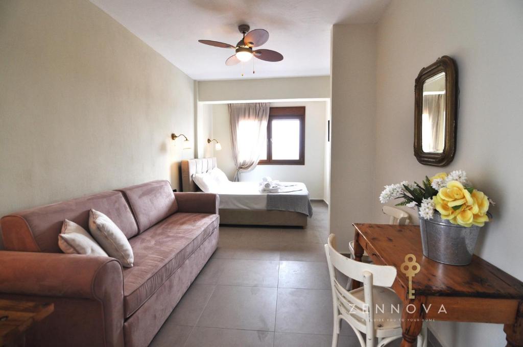 a living room with a couch and a table at Zennova #61, Boutique Studio in Nikiti in Nikiti