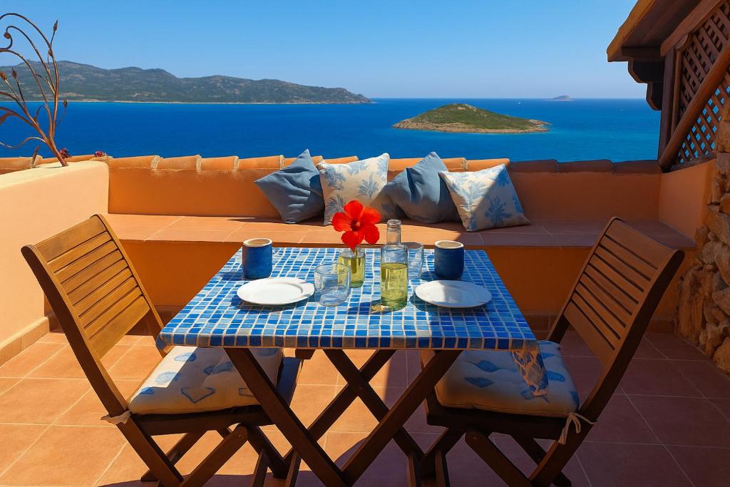 a table and two chairs with a table and a couch at Punta Est - Mono OSTRO Terrazza Fronte Mare in San Teodoro