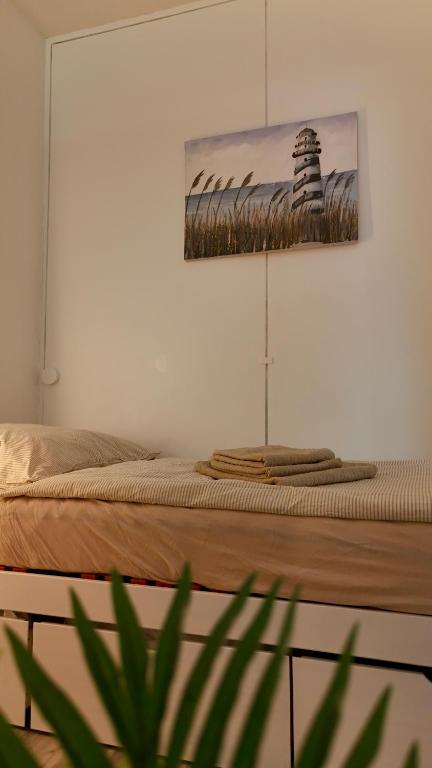 a bed in a room with a picture on the wall at Strandgrün Moderne Ostsee-FeWo am Hansa-Park in Sierksdorf