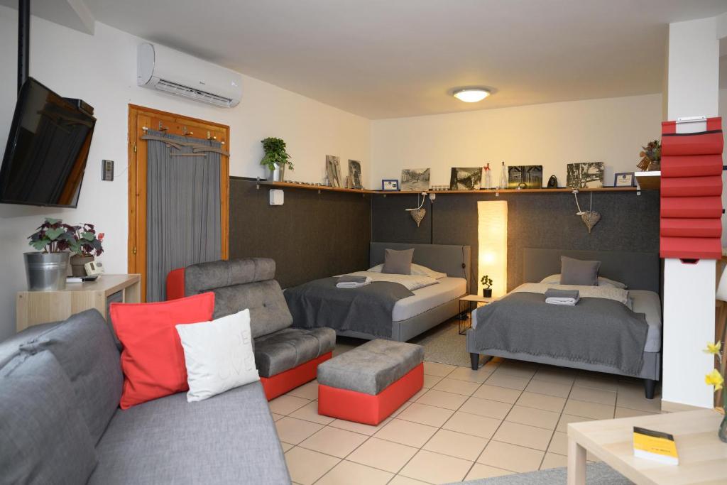 a living room with two beds and a couch at Borálom Stúdió Apartman Tokaj in Tokaj
