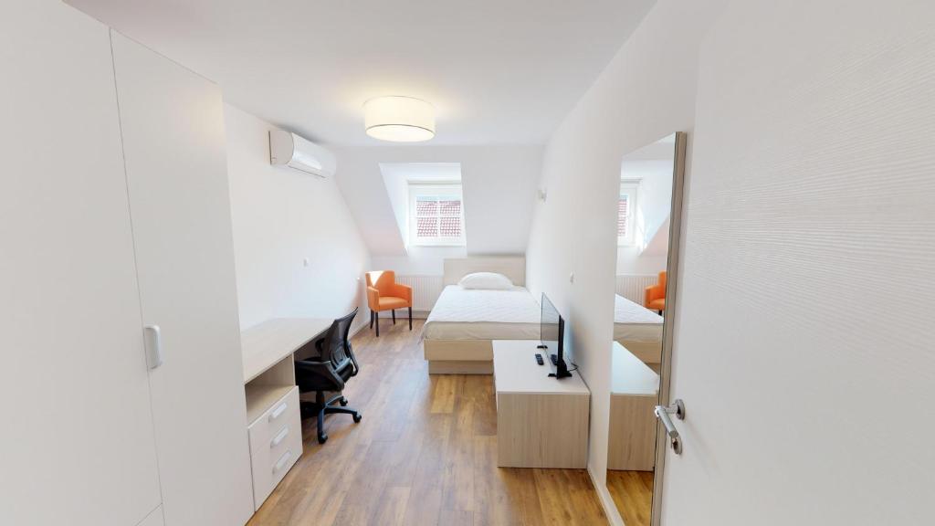 a bedroom with two beds and a desk and a mirror at Mestna Vila Krško in Krško
