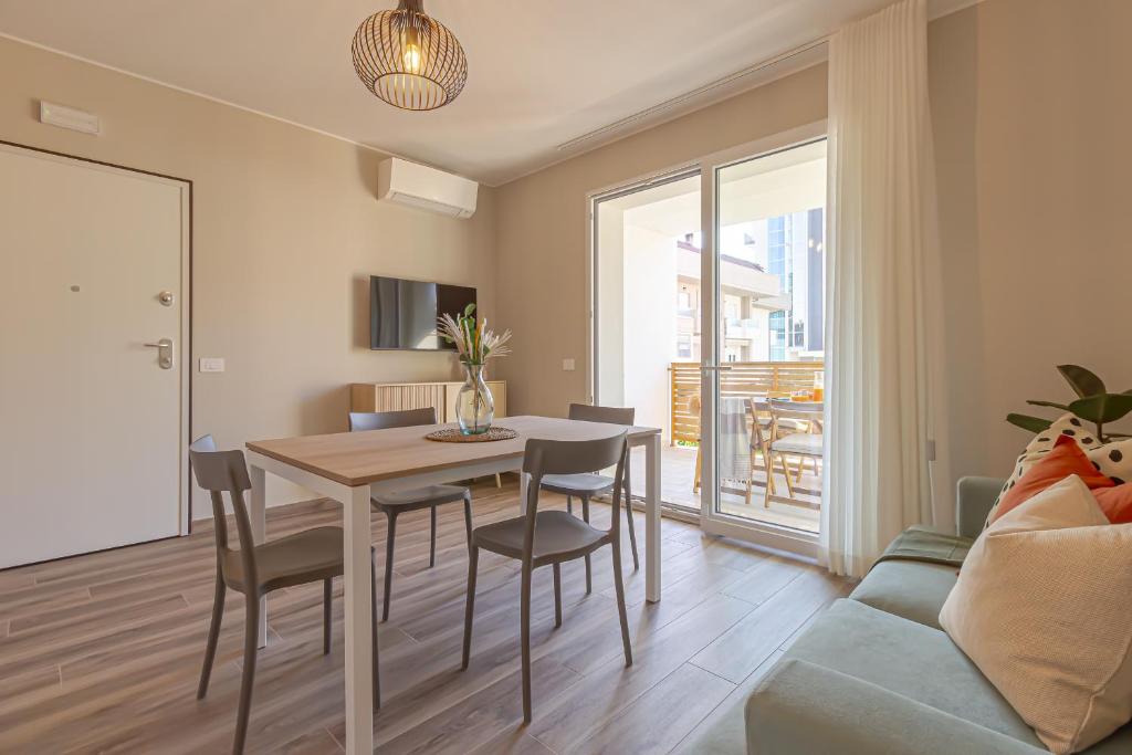 a living room with a table and chairs and a couch at Appartamenti al Mare - Il Riparo d'aMare in Alba Adriatica