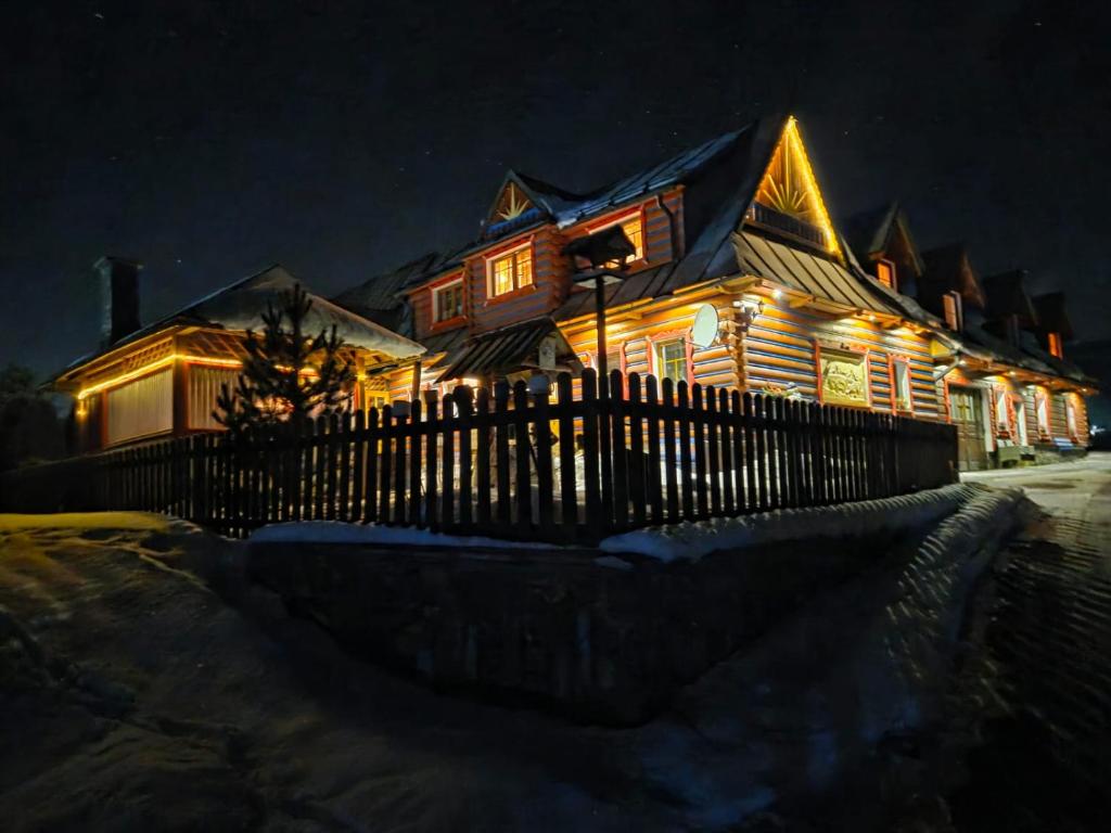 a house lit up at night with lights on it at Penzión Stodola in Ždiar