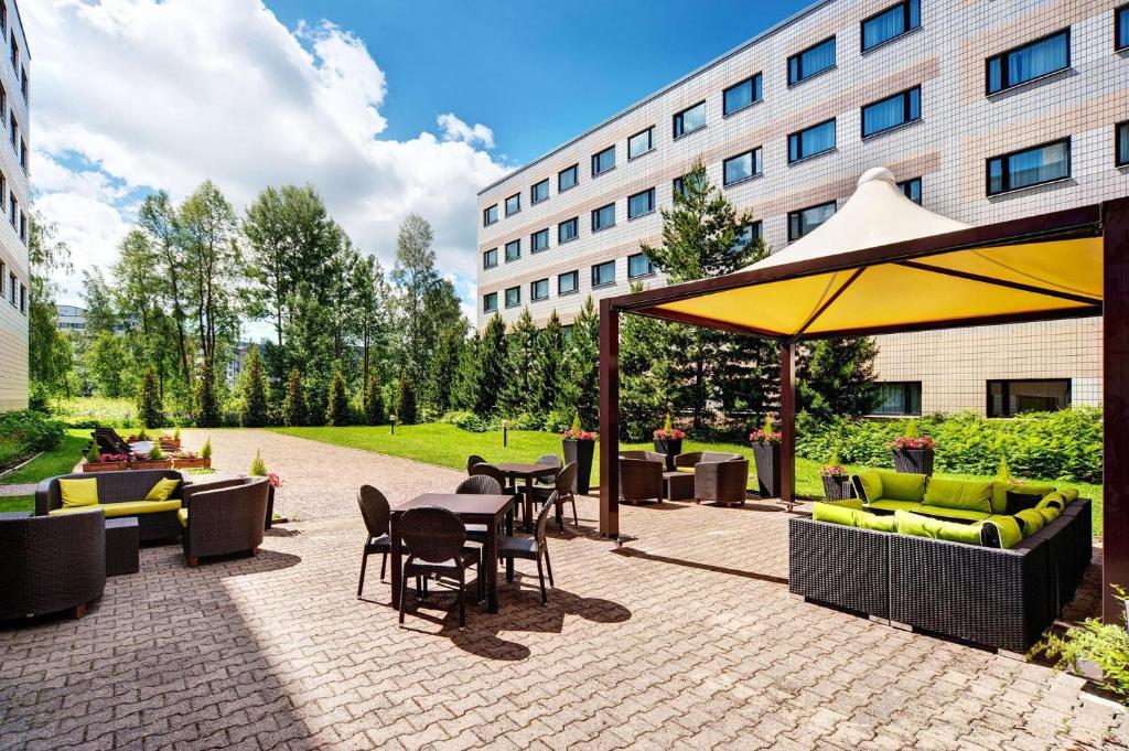 a patio with a table and chairs and an umbrella at Scandic Veromies in Vantaa