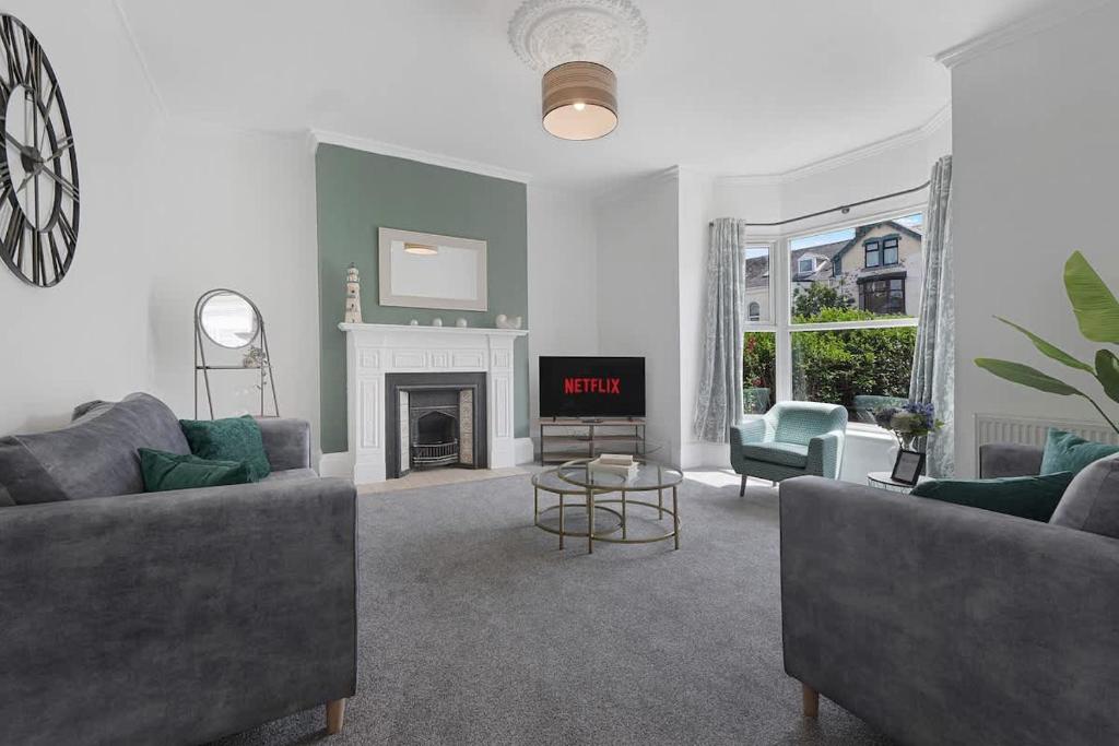 a living room with two couches and a fireplace at Spacious! 6BR in Beach Road in South Shields