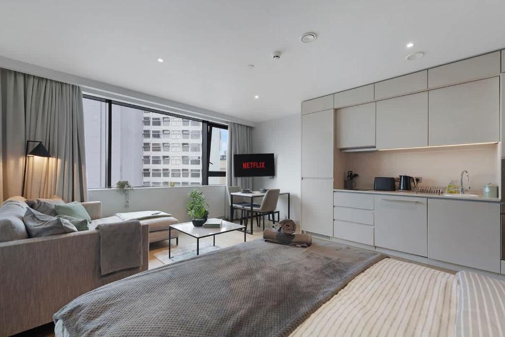 a living room with a couch and a kitchen at Stylish Studio With Wi-Fi and Shared Spa Facilities in Manchester