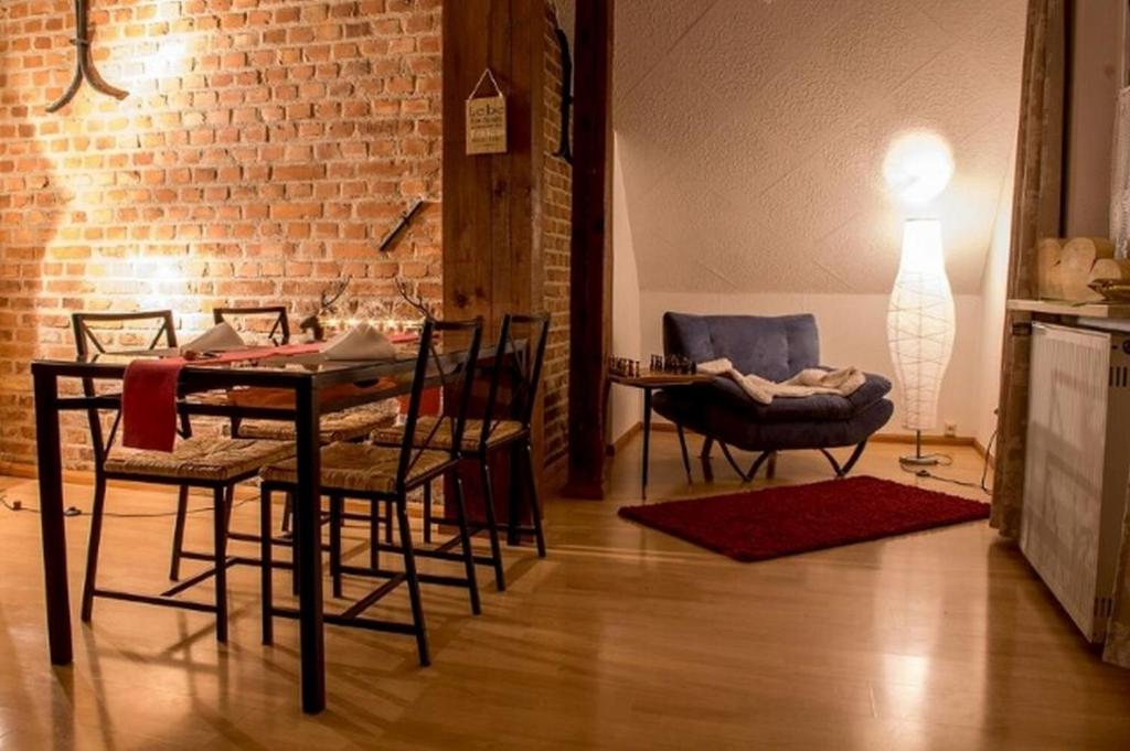 a dining room with a table and chairs and a brick wall at Kuschelige Ferienwohnung in Schwandorf in Bayern