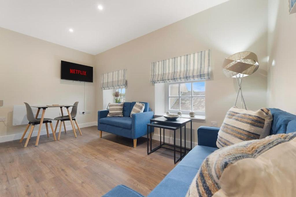 a living room with a blue couch and a table at Flat3 1BR in Horsemarket in Barnard Castle