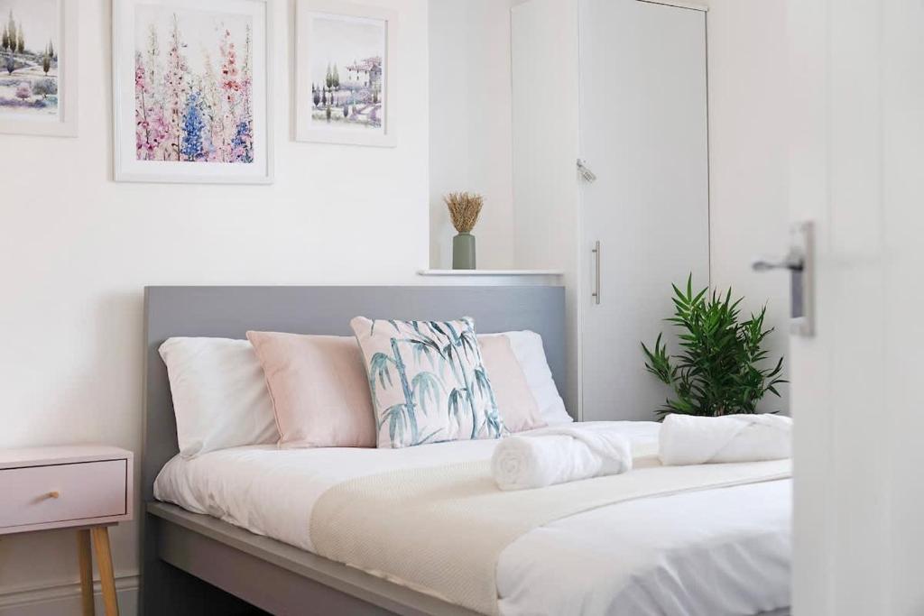 a bedroom with a bed with white and pink pillows at New! 4BR in Durham Road in Annfield Plain