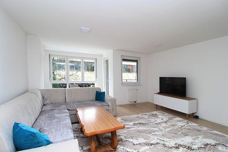 a living room with a couch and a flat screen tv at Apartman Dijamant in Sarajevo