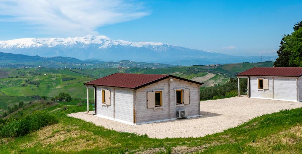 two small buildings on a hill with mountains in the background at Atessa Escapes in Atessa