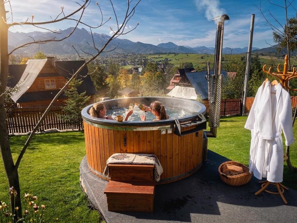 a hot tub with people in it in a yard at Hole in Zakopane