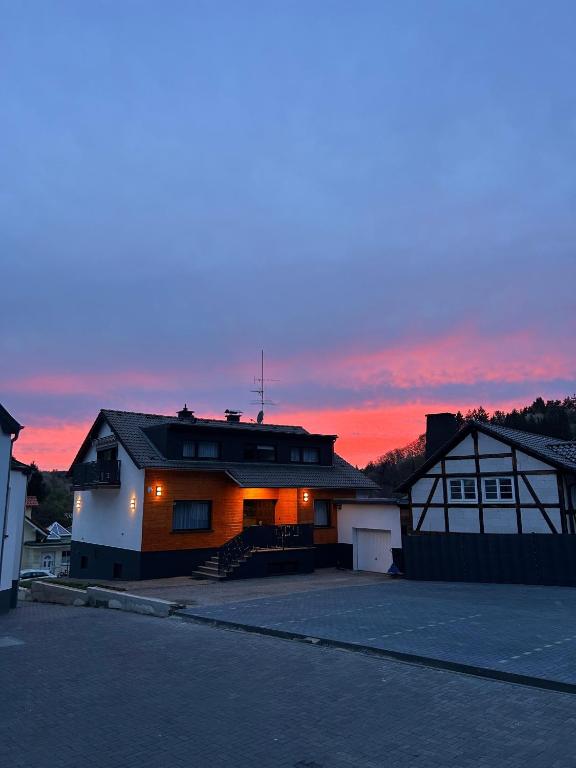 a house with a parking lot in front of a sunset at Buttermarkt House ``Rooms at the Ring`` in Adenau