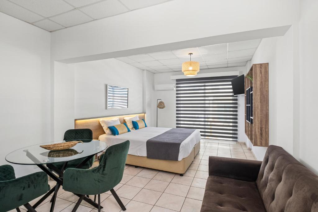a bedroom with a bed and a table and chairs at Larnaca Bay Suites in Larnaca