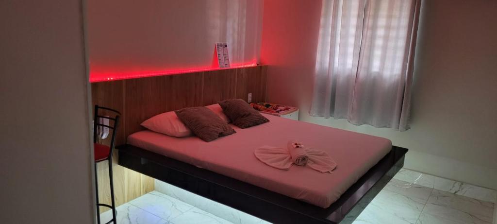 a bedroom with a pink bed with a pink bow on it at Hotel Suíte in Brasília