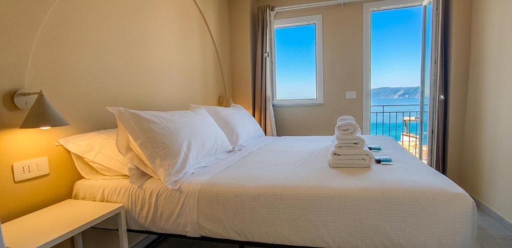 a bedroom with a bed with a view of the ocean at Nest Scilla in Scilla