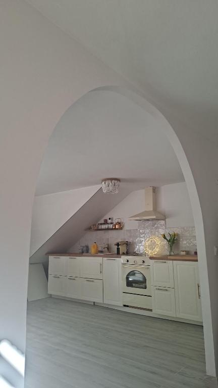 a white kitchen with an archway in a room at Amira home suite in Sant Pere de Ribes