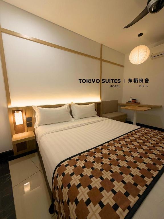 a bedroom with a large bed with a tokyo suites sign at Tokiyo Suites Hotel Kinta River Ipoh Town in Ipoh