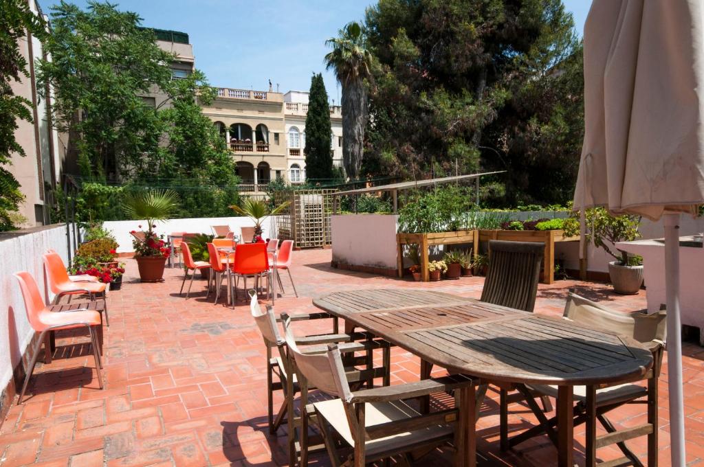 un patio con mesa, sillas y sombrilla en Studio Hostel, en Barcelona