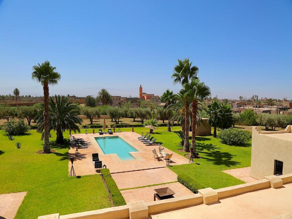 an aerial view of a resort with a pool and palm trees at Palais Nova in Marrakesh