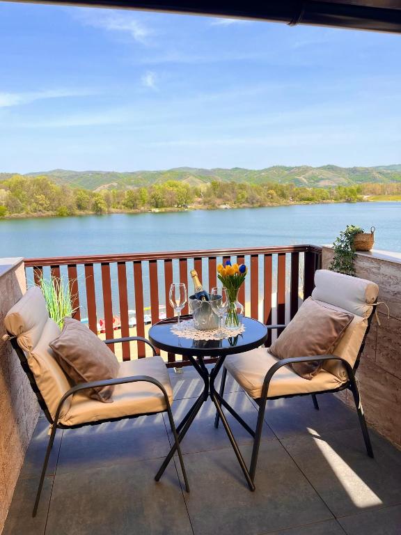 a table and chairs on a balcony with a view of a lake at Dionis in Veliko Gradište