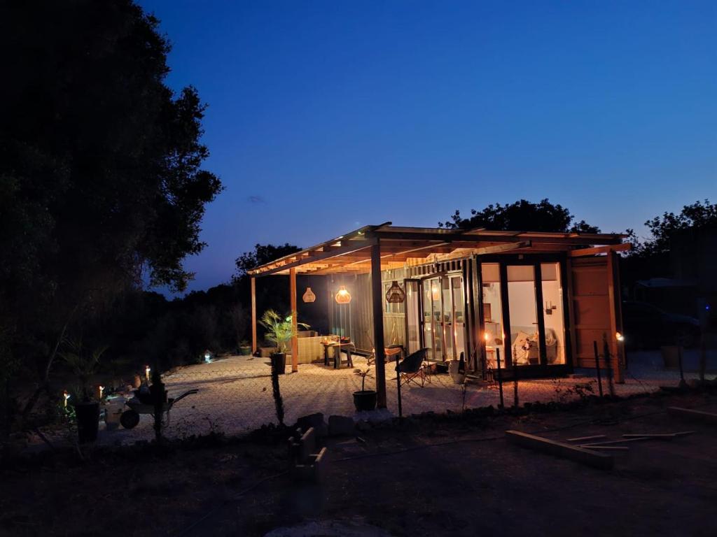 a small building with glass windows at night at Eco Hideaway in Anoyira