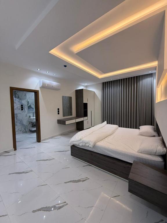 a large bedroom with a large bed and a mirror at درة القيم in Taif