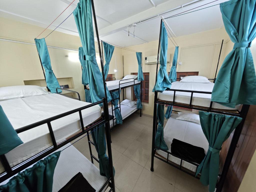 a room with three bunk beds in a hospital at Evara Stays Backpackers Hostel in Kolkata