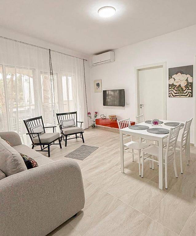 a living room with a couch and a table and chairs at VERA apartament in Fushë-Draç