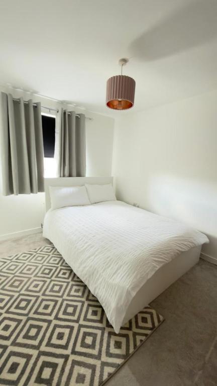 a bedroom with a white bed with a rug at Suite 3 En-suite Room with Double Bed in Edinburgh