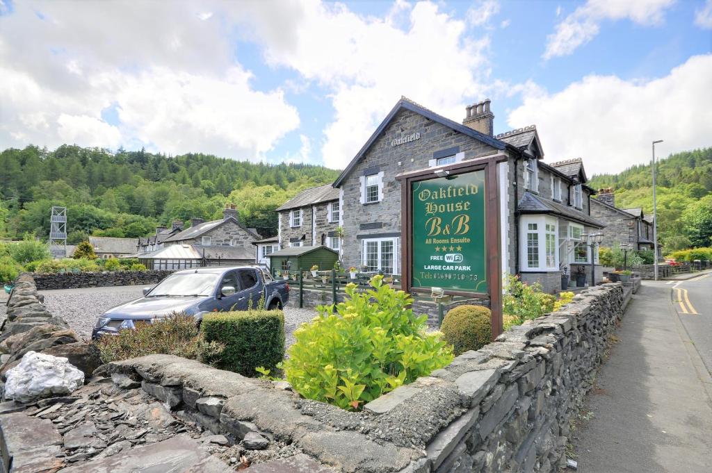 a sign in front of a building in a village at Oakfield House Bed and Breakfast in Betws-y-coed
