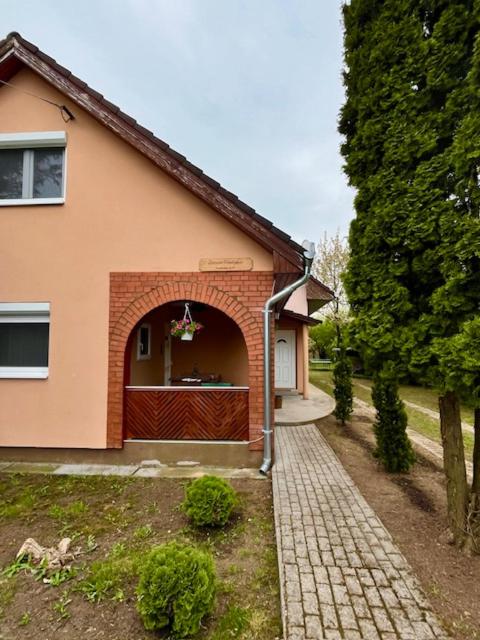 a house with a red door and a brick walkway at Demeter Vendégház in Tiszanána