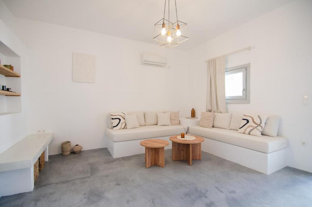 a white living room with a white couch and a table at Ios Pearls-2 houses in Mylopotas