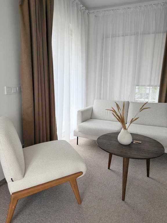 a living room with a white couch and a table at Izabelės apartamentai in Palanga