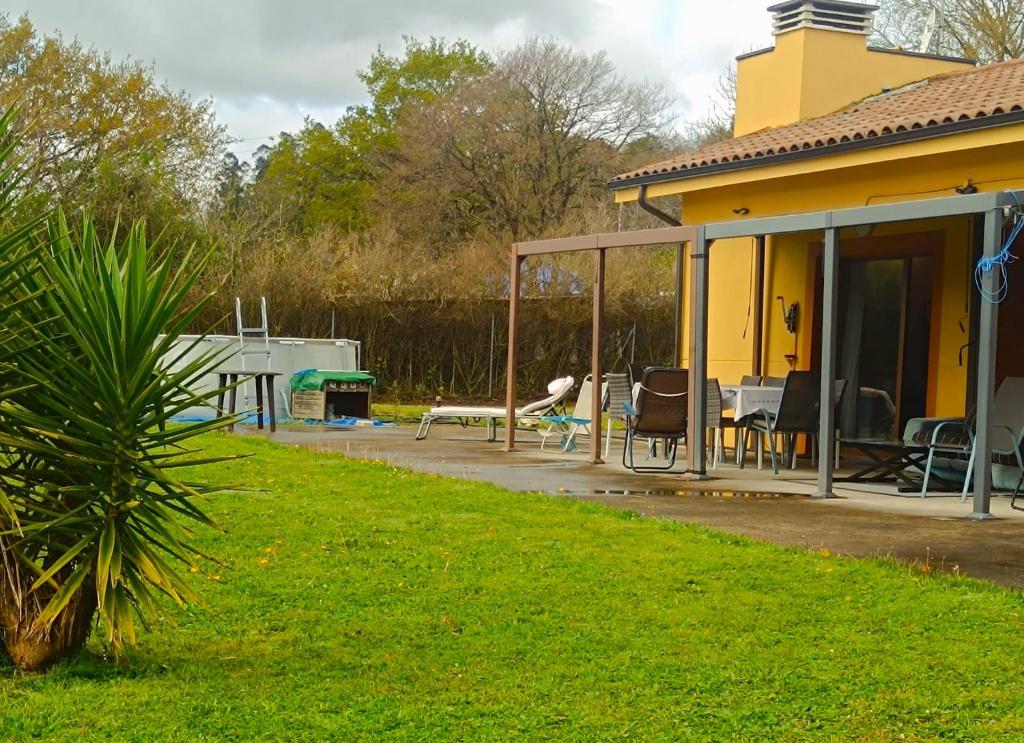 a yellow house with a patio and a table and chairs at My Reyna in San Miguel